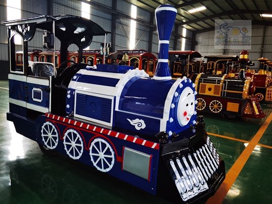 The front of the locomotive replicates the silhouette of a classic steam locomotive, featuring the iconic chimney and round headlights; the body is based on a deep navy blue base, accented with contrasting white and silver lines and a black base, with red rivet details along the edges, creating an overall retro mechanical aesthetic.