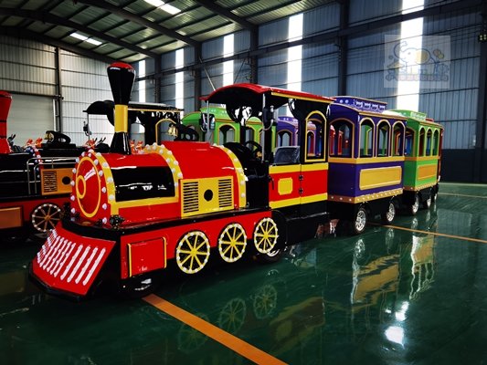 The front of the locomotive replicates the classic silhouette of a steam locomotive, paired with rounded yellow wheels; the multiple carriages continue the same retro court style, with bright and cheerful colors.